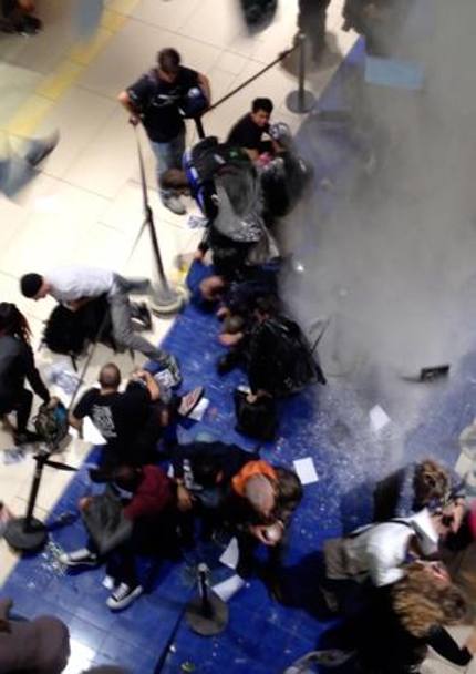 Un fermo immagine  mostra un momento del blitz del cosiddetto Blocco studentesco con uova e  farina contro la gente in fila per l&#39;iPhone 6 nel Centro commerciale della capitale Porta di  Roma. (foto diffusa dall&#39;Ansa)